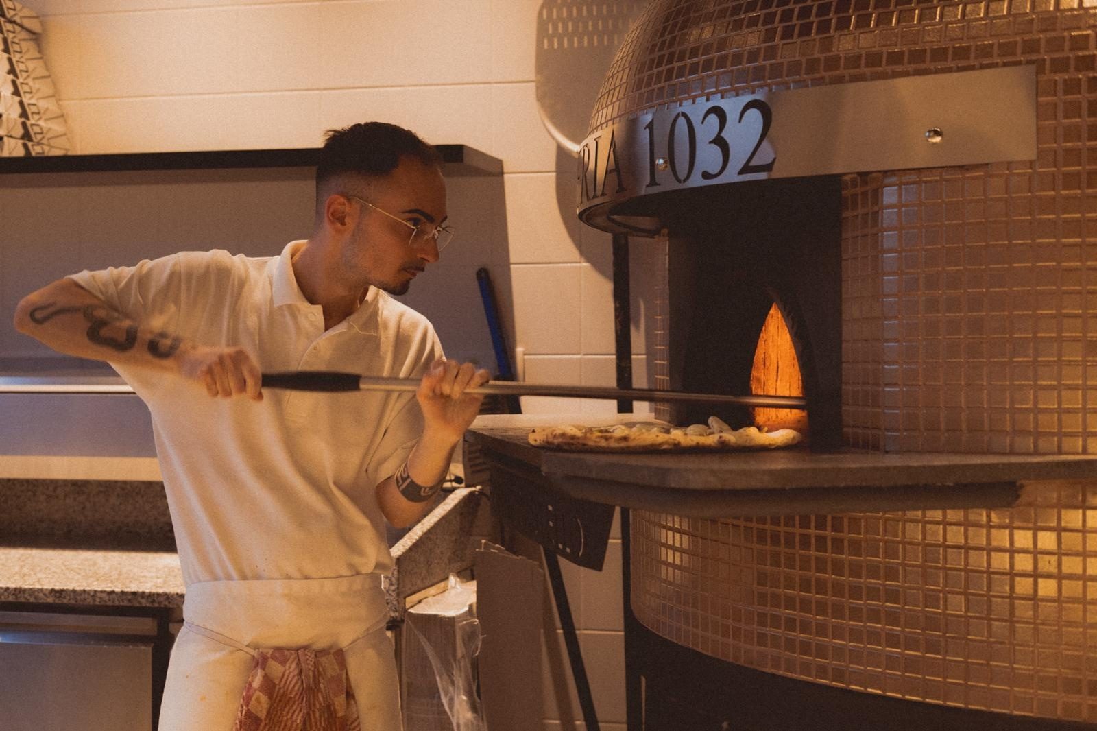 Pizzaiolo enfournant une pizza à la Pizzeria 1032