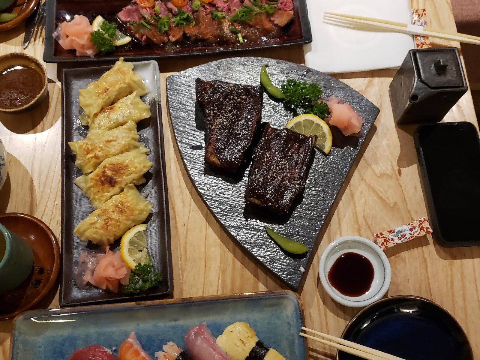 Table dressée au Samouraï avec gyôza, sushis et viande grillée à la japonaise