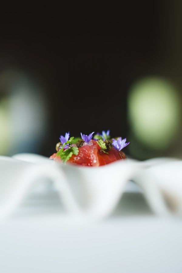 Bouchée de poisson cru et fleurs comestibles au restaurant Sanzarù à Bruxelles