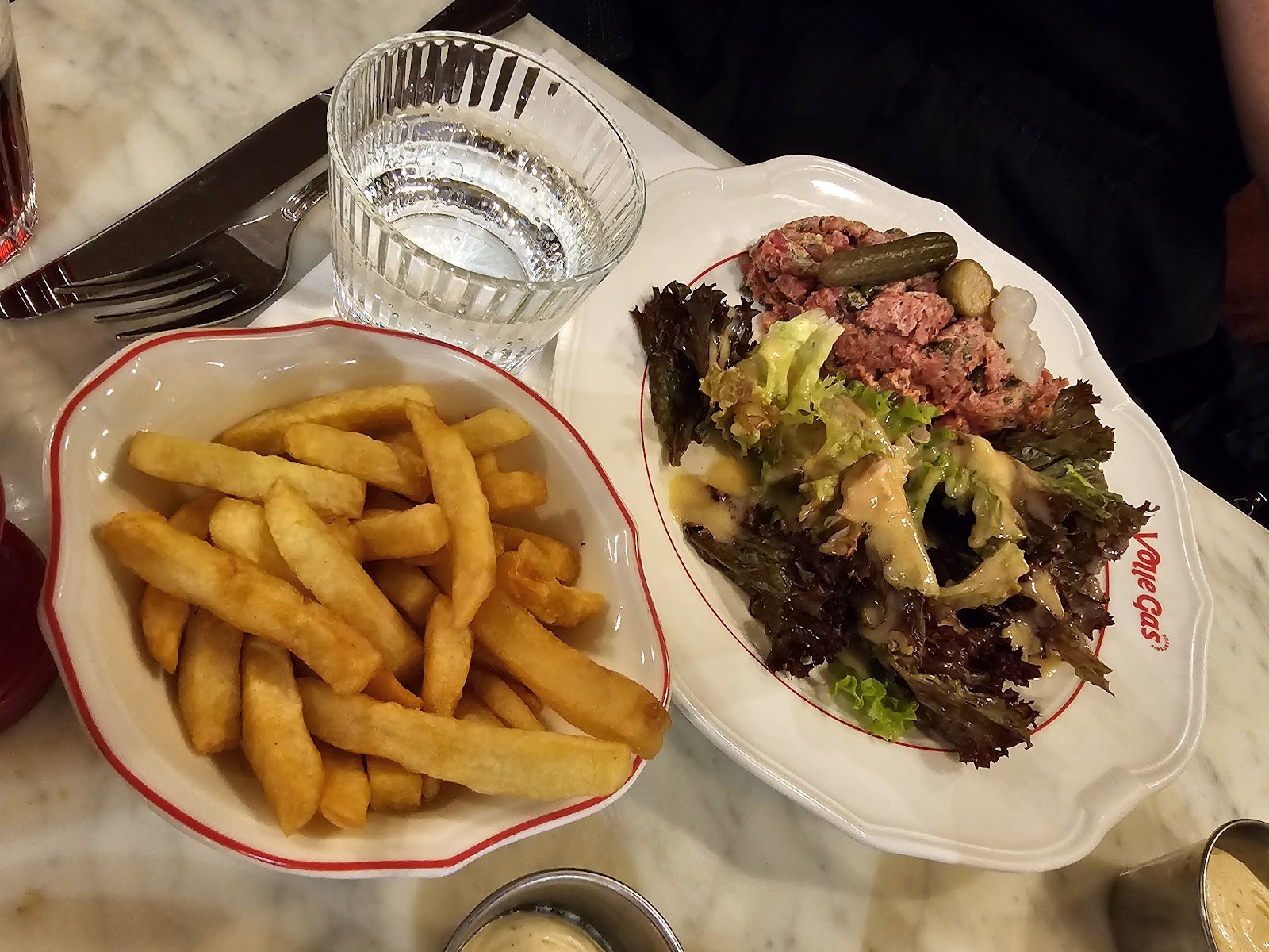 Assiette d'américain préparé avec salade et frites servie chez Volle Gas