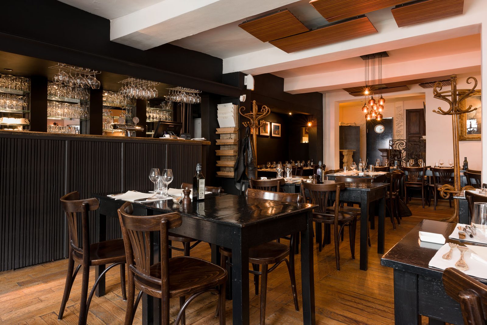 Salle en bois sombre du Wine Bar des Marolles avec bar au fond
