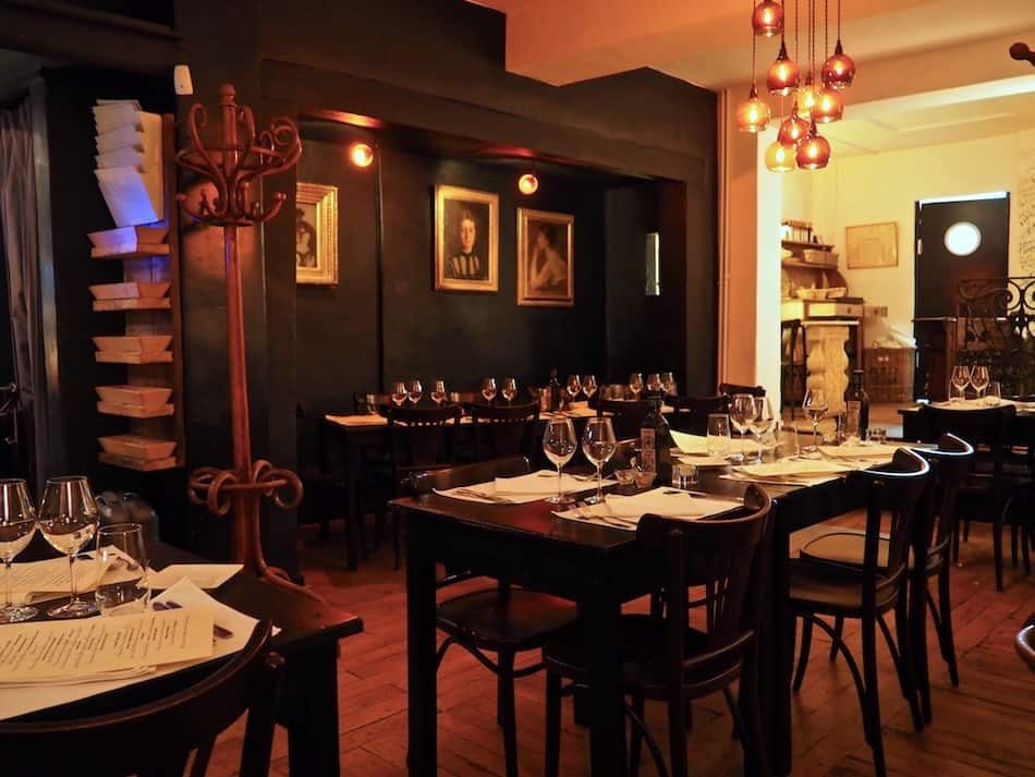 Salle du Wine Bar des Marolles éclairée par des suspensions cuivrées